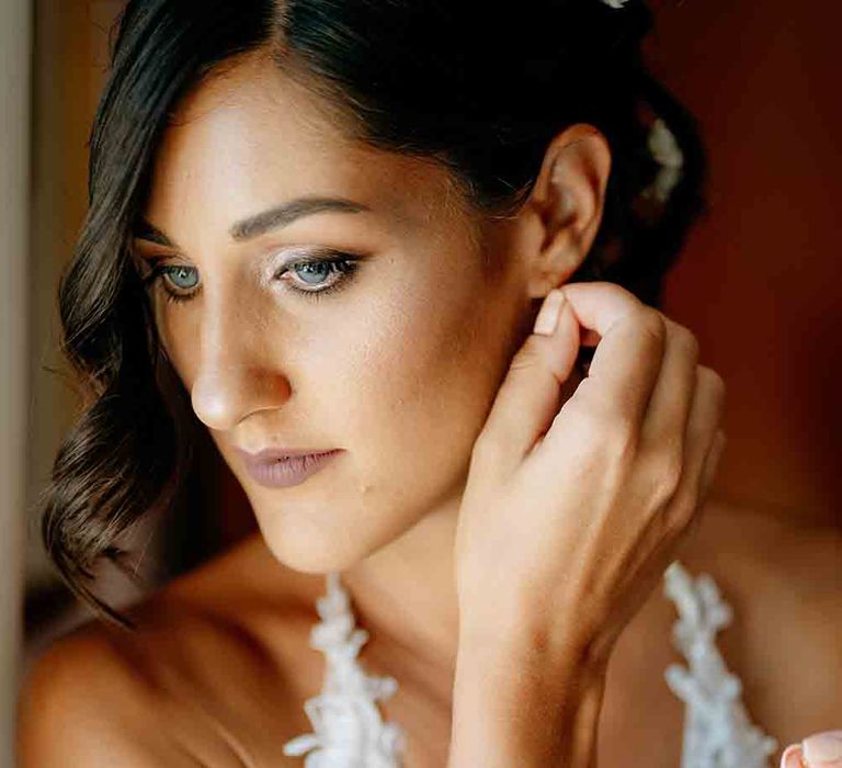 Bride with smokey eye makeup during preparations for romantic Italian wedding