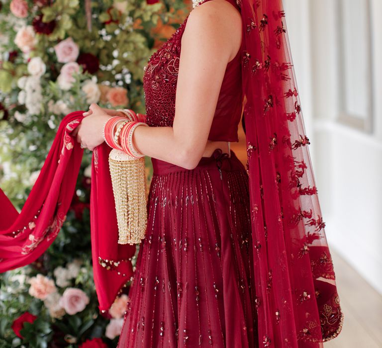 Bride stands with floral wall in the background