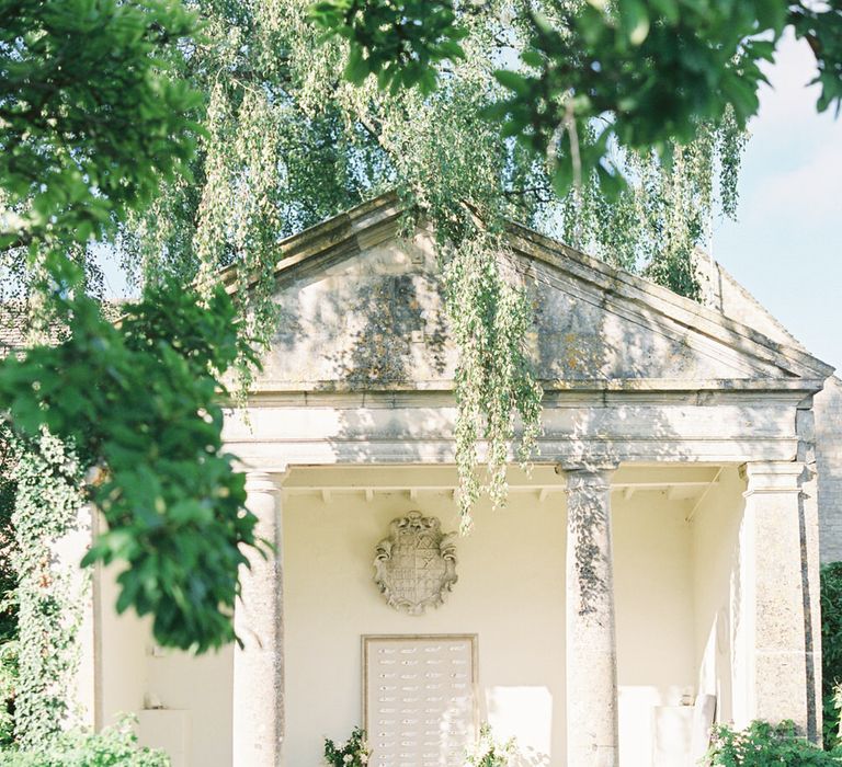 Outdoor wedding ceremony by the pond at Barnsley house for English garden party wedding