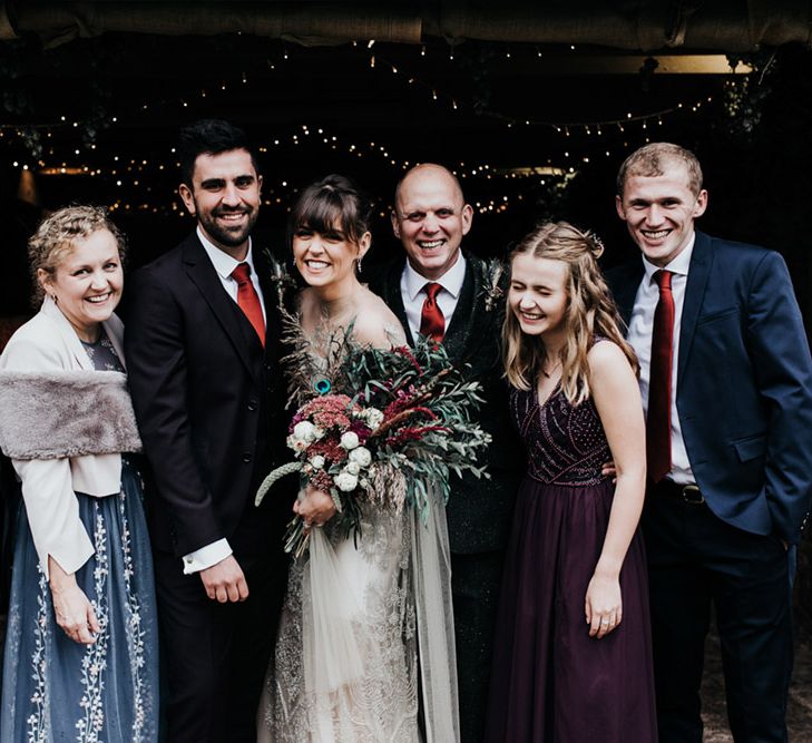 A group wedding shot. The bride holds an oversized homemade wedding bouquet.