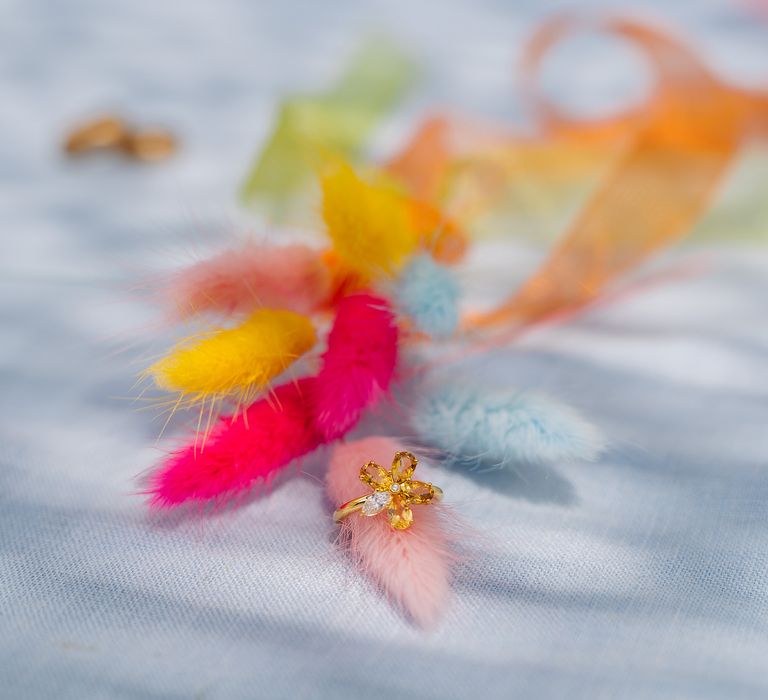 Flower shaped ring is placed around colour feather