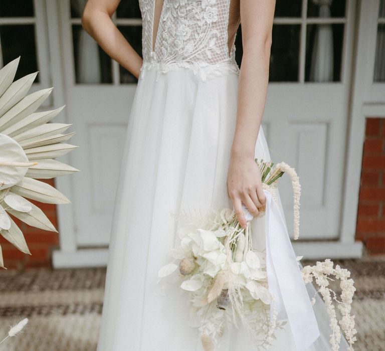 Bride holding an all white bouquet with a mix of dried and fresh flowers