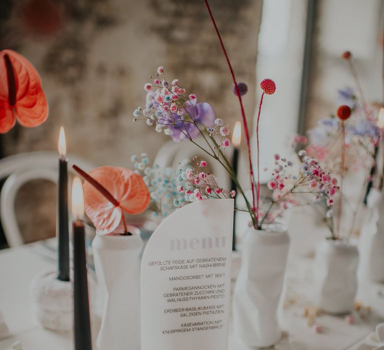 Perspex menu sign and pastel wedding flower stems in vases at candy inspired wedding 