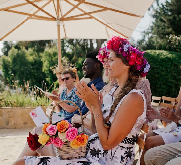 Bridesmaid in bright pink flower crown with basket of vibrant roses