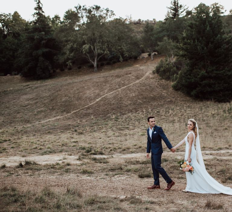 Bride & groom walk along the countryside in the US for woodland elopement