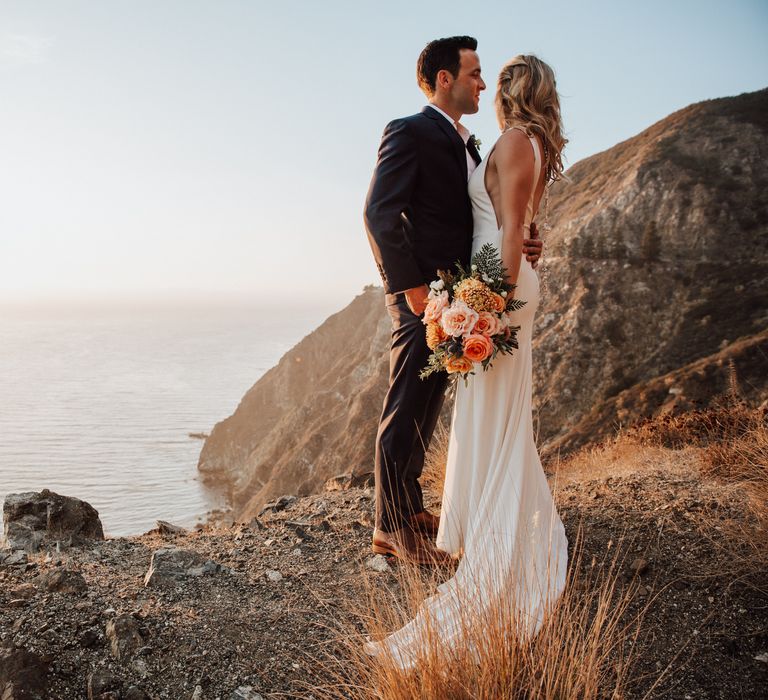 Groom wraps his arm around bride on their wedding day 