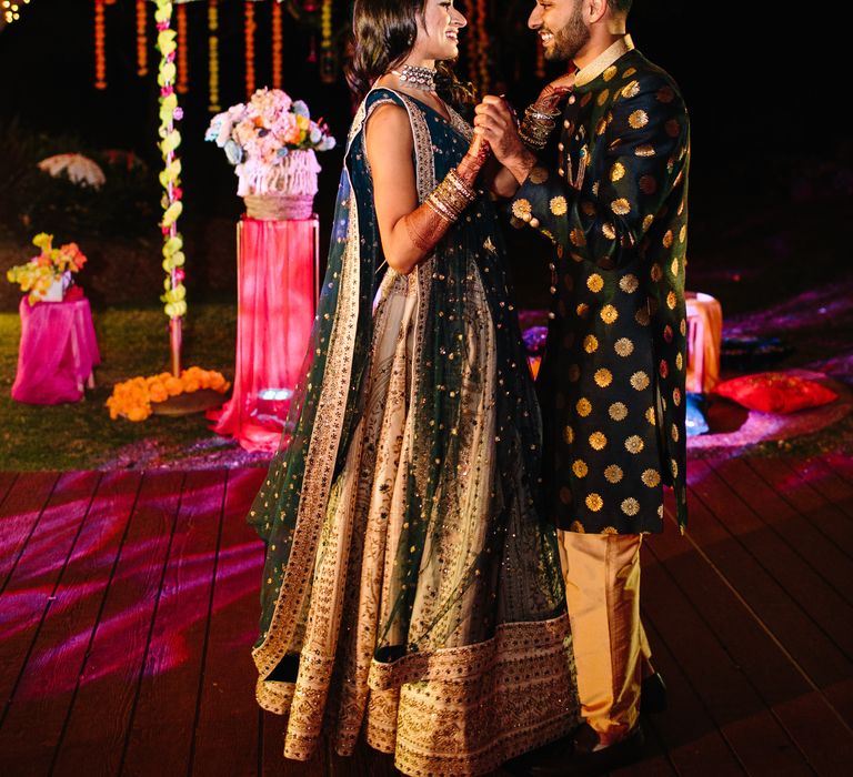 Bride & groom hold one another outdoors during their Sangeet night 