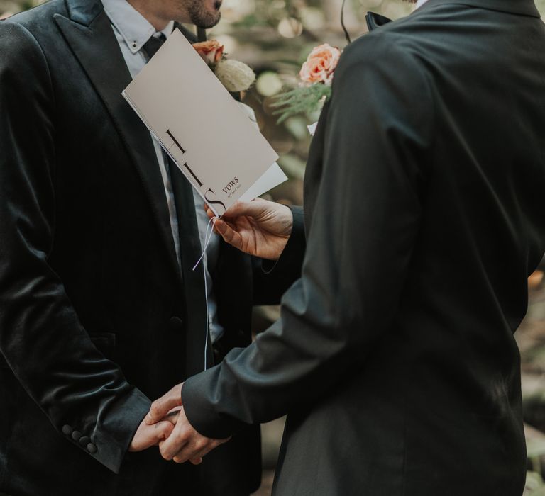 Groom reading his vows from a vow booklet 