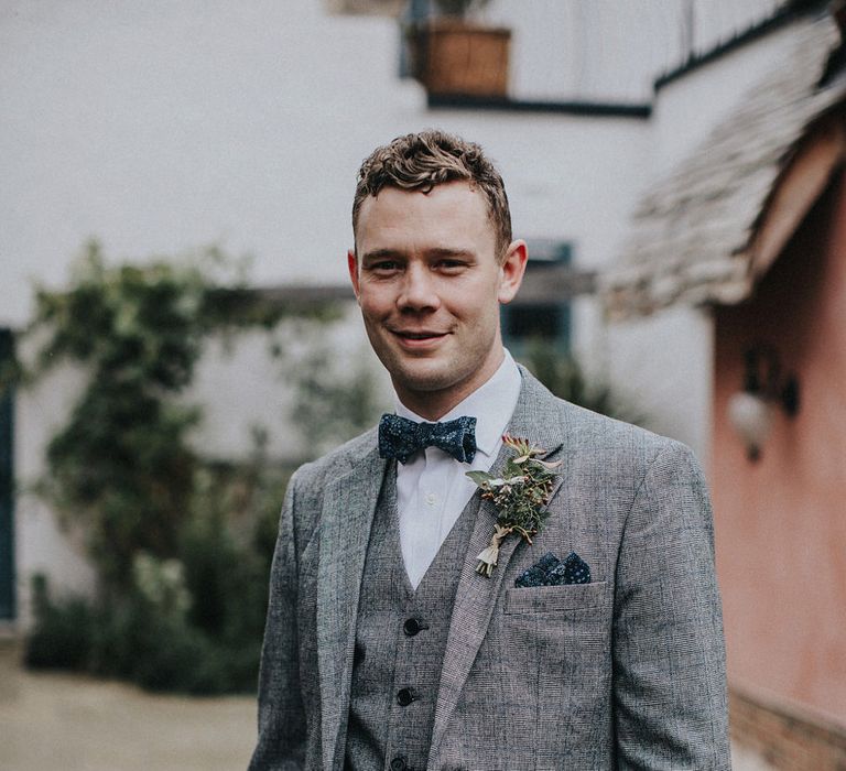 Groom in a matching grey blazer and waistcoat with blue check design