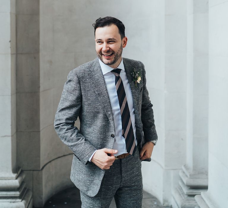 Groom in a grey wedding suit with white specs at Old Marylebone Town Hall wedding 