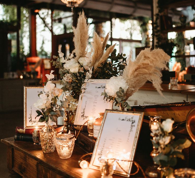 Pampas grass florals on wooden table complete with silver frames