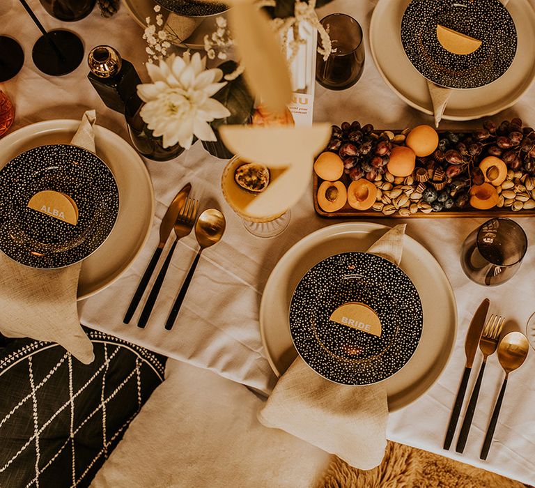 Place setting with coloured table ware and fruit and nut table decor and centrepieces 