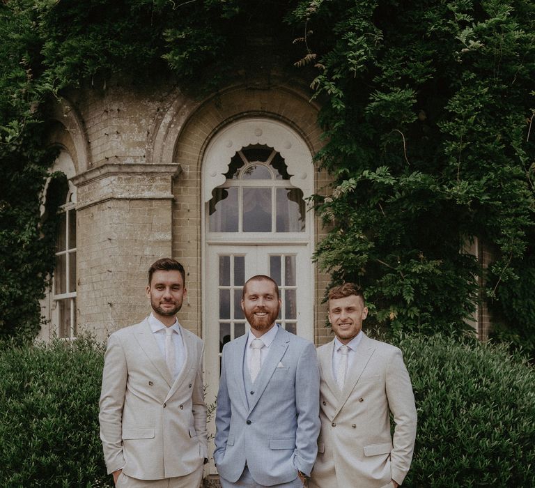 Groom in pale blue suit with groomsmen in cream wedding suits