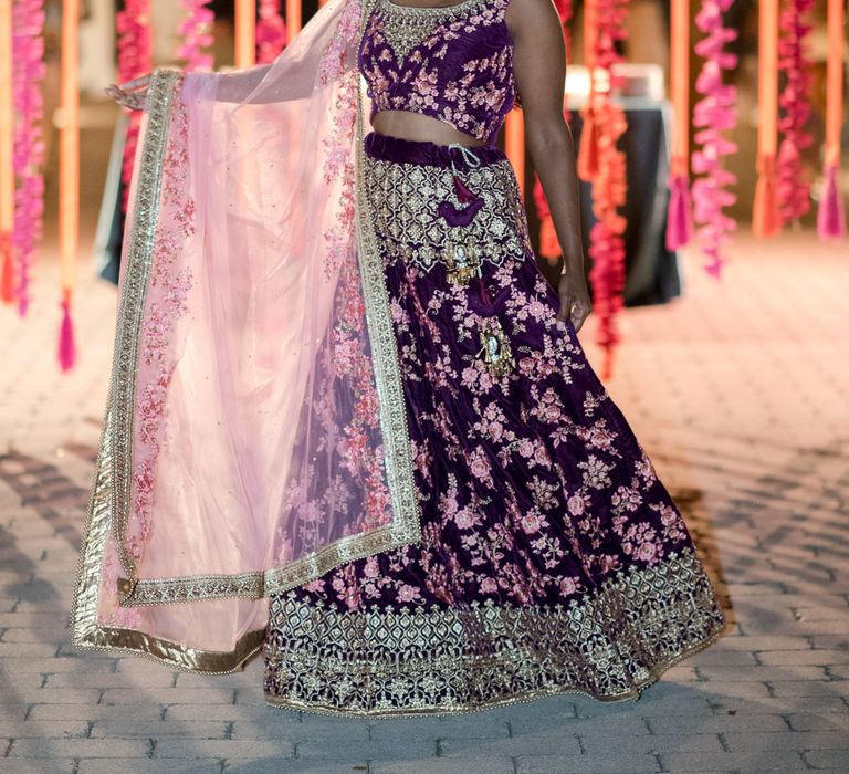 Indian bride wears traditional Lahenga in purple and gold complete with floral embellishments