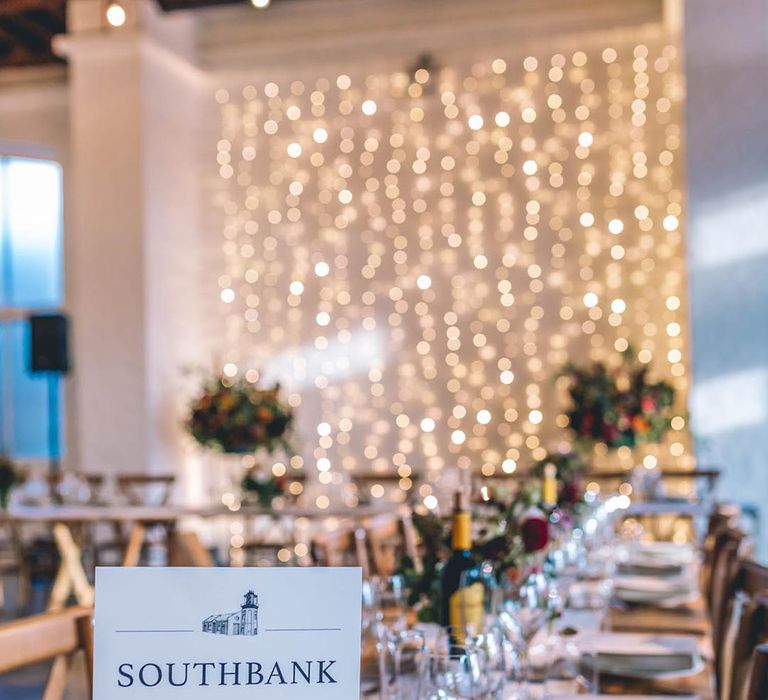 London table names with fair light backdrop at The Chainstore Trinity Buoy Wharf wedding venue