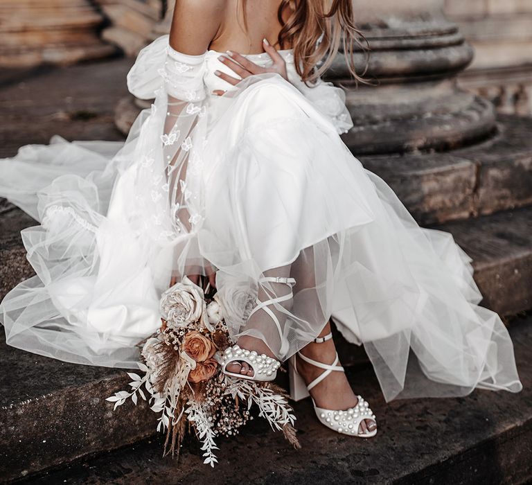 Bride in a tulle Daniel Chu wedding dress, pearl headband and Charlotte Mills wedding shoes 