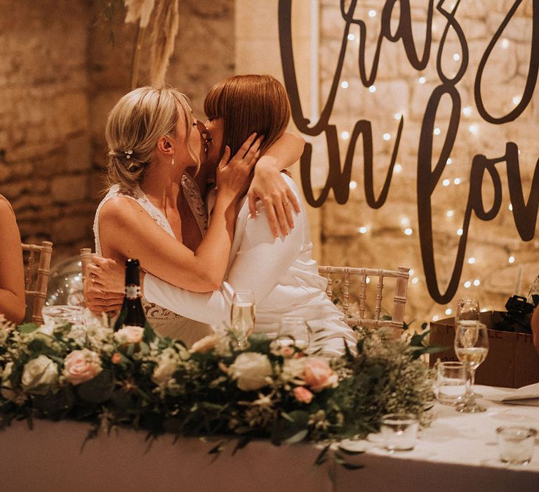 Brides kiss with crazy in love backdrop