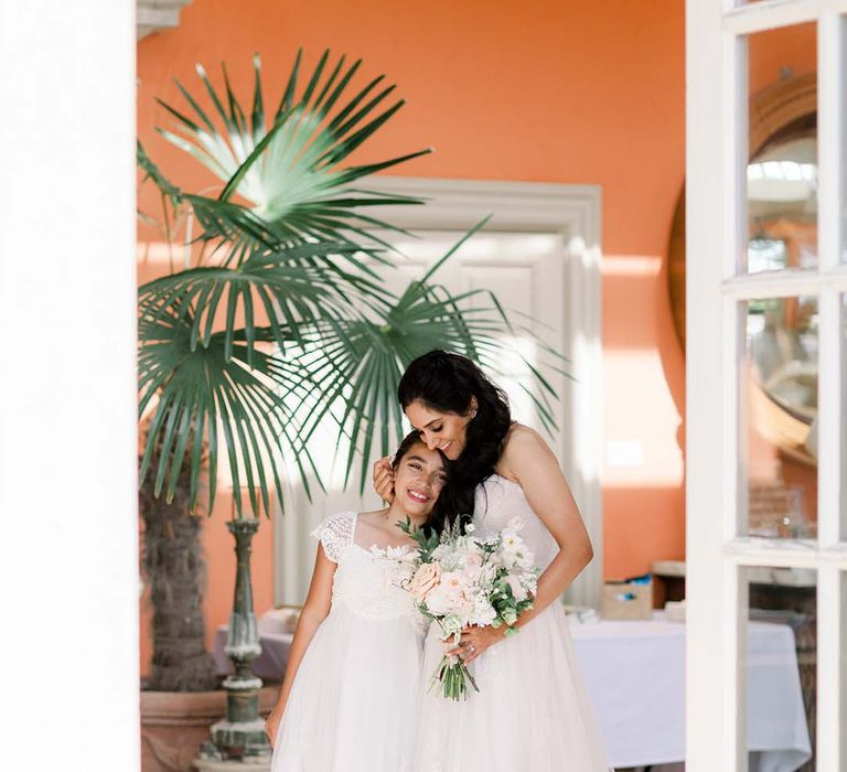 Bride hugs flower girl in The Orangery at Euridge Manor