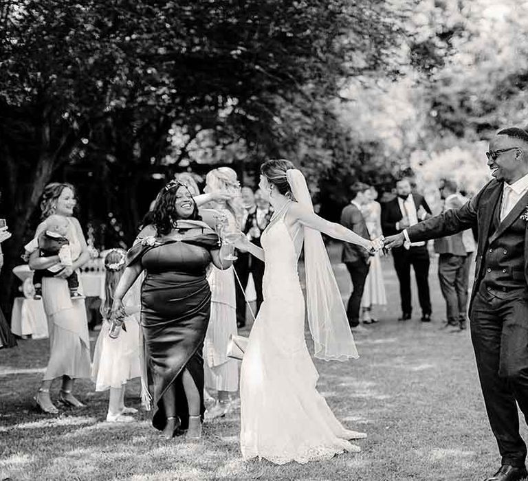 Bride & groom dance with wedding guests outdoors to gospel choir 