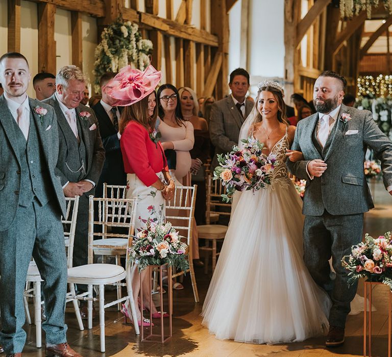 Bride walks down the aisle in tulle skirt with deep plunging v-neck wedding dress with sparkles