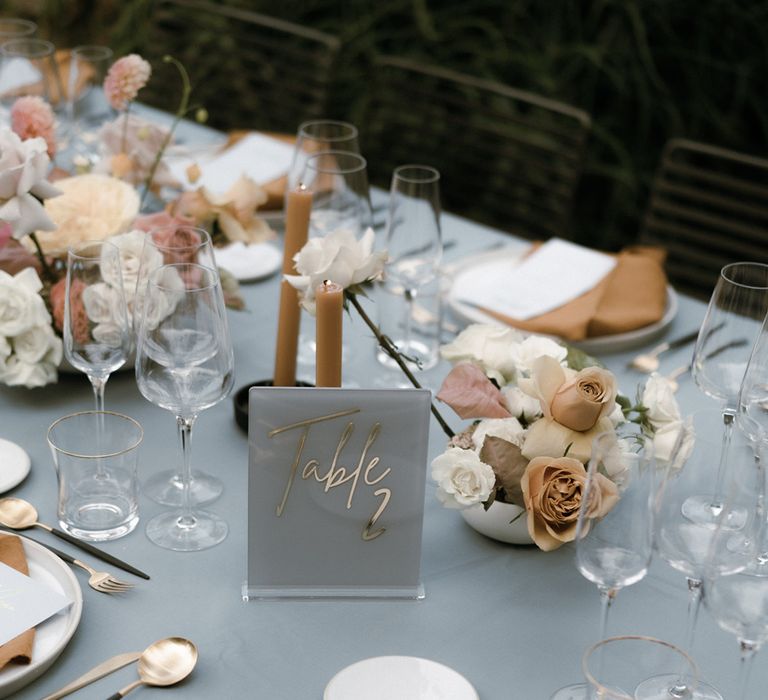 Acrylic grey and gold table number sign on grey tablecloth with pastel toffee coloured details for table setting