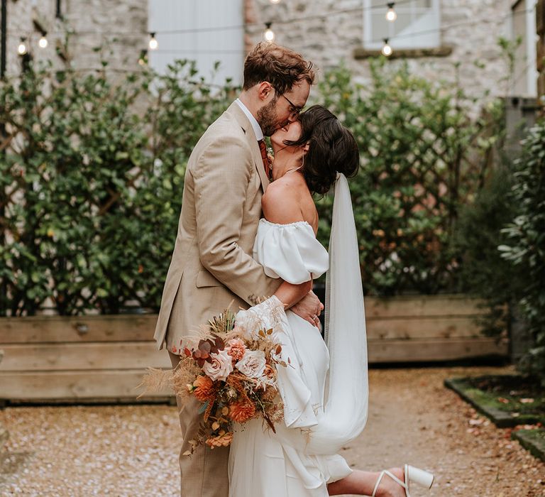 Bride has her foot popping moment as she shares a kiss with her new husband