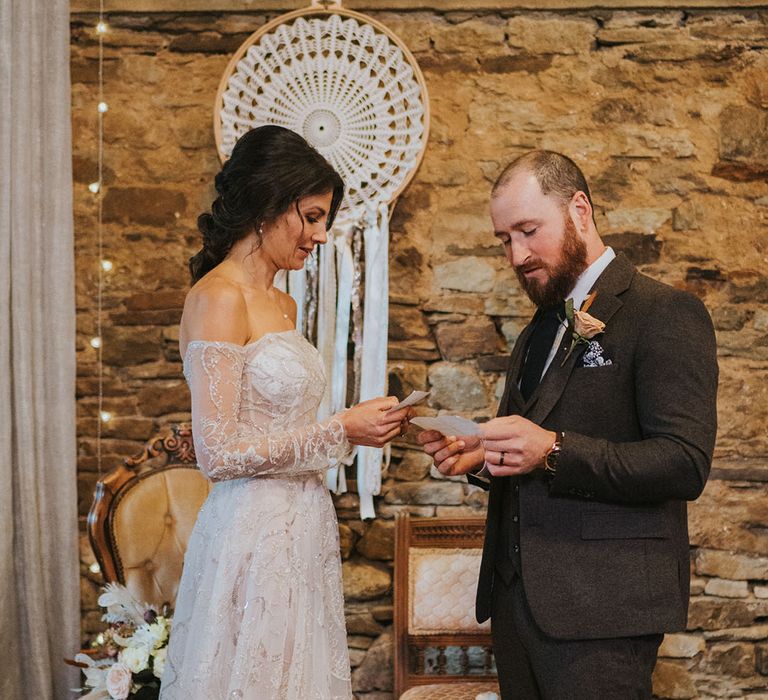 Bride and groom read their vows to each other for rustic wedding at Ash Barton wedding venue