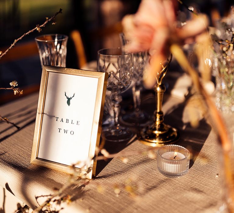 Table name sign with stag emblem in gold photo frame