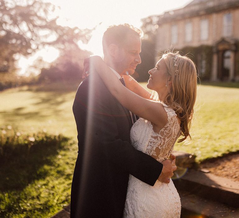 Bride and groom embrace each other during golden hour as they look into each other's eyes