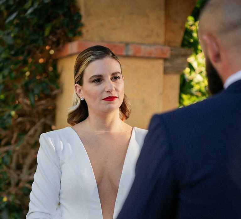 Bride wears her blonde hair slicked back and red lipstick on her wedding day