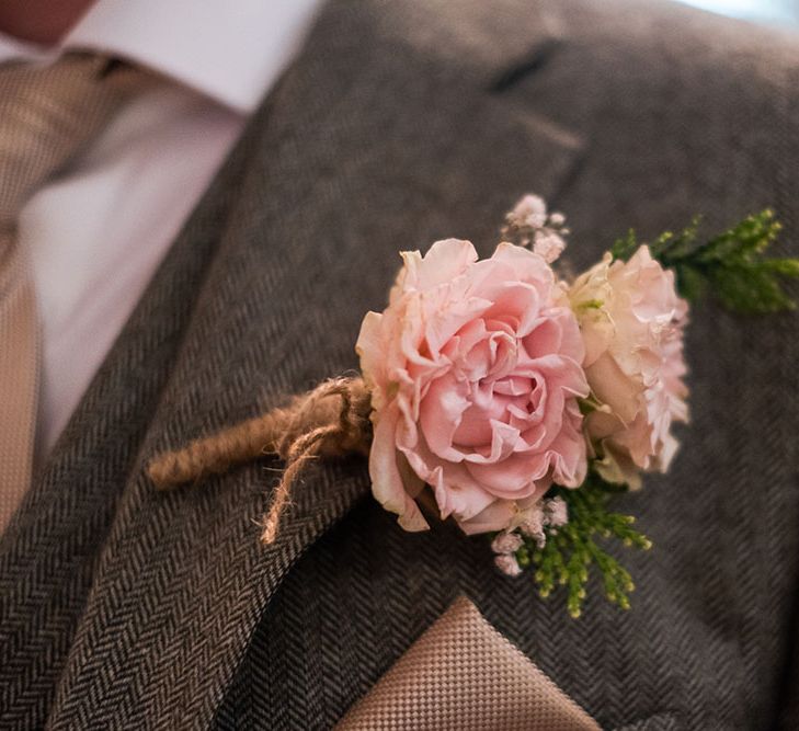 Pale pink floral buttonhole tied with brown string 