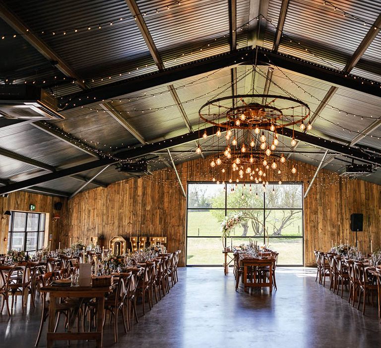 Silchester Farm wedding reception room with fairy lights and festoon lighting with pink rose floral moongate