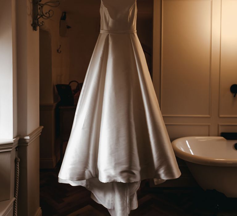 Classic satin Sassi Holford wedding dress with halter-neck, simple waistband and princess skirt