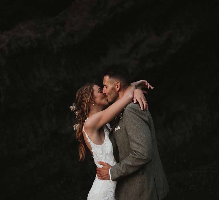 Bride & groom embrace outdoors on the beach for couples portraits after wedding ceremony