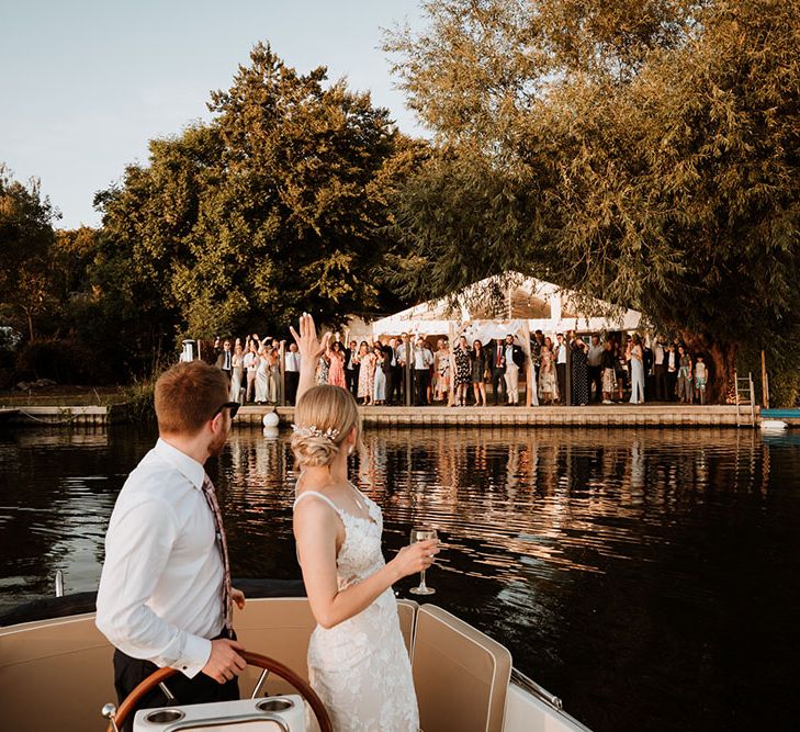 Bride & groom leave marquee wedding reception on boat ride across the Thames on their wedding day