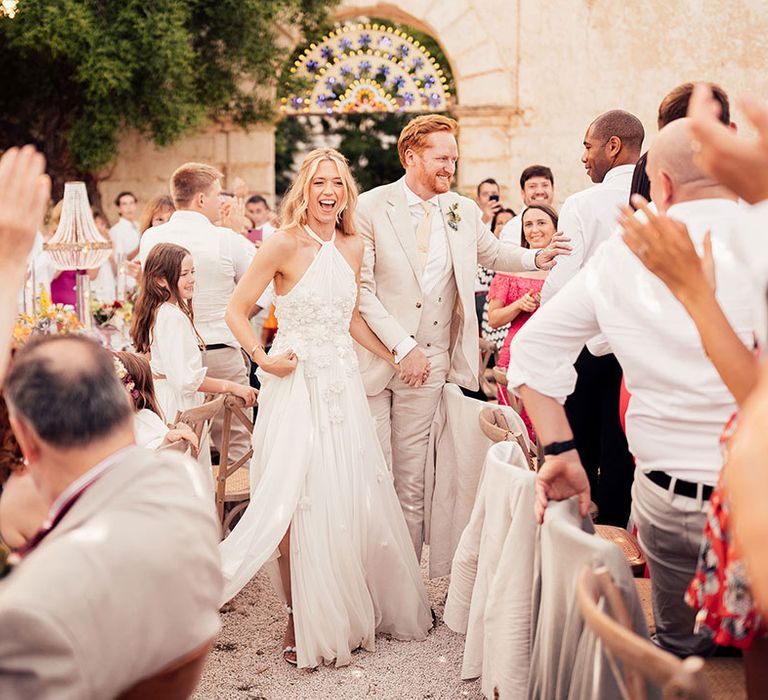 Bride and groom greet their wedding guests as they enter their wedding reception 