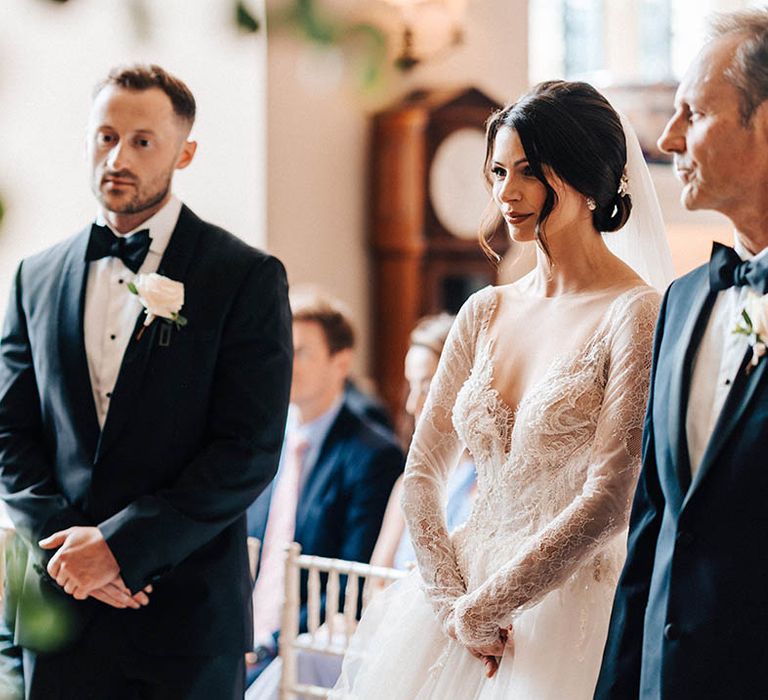 The groom, father of the bride and the bride all stand at the altar for the civil wedding ceremony 