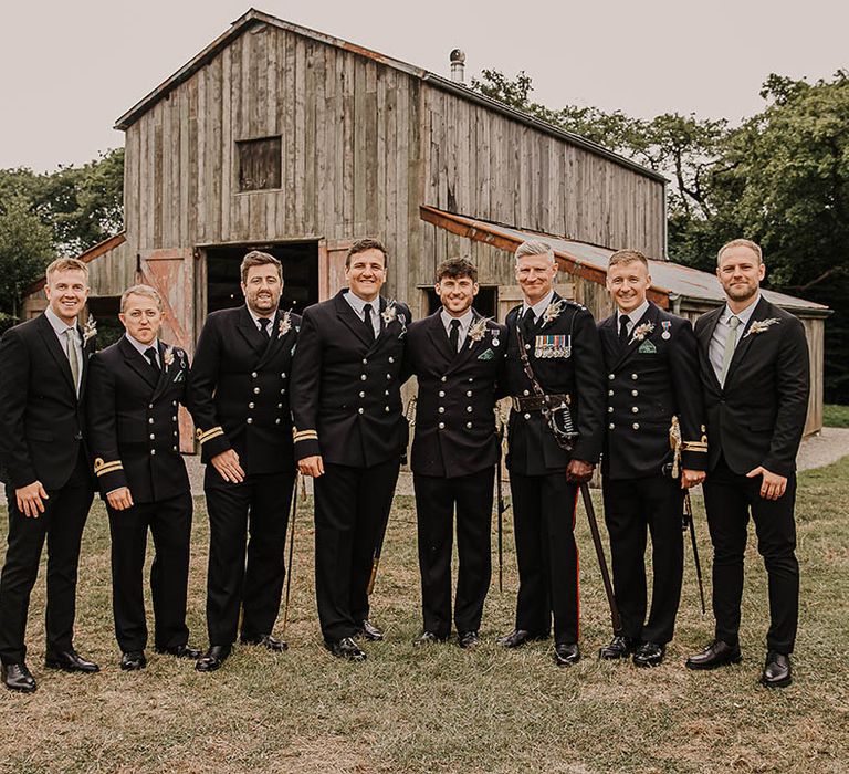 Groom with the groomsmen and male family members in traditional military uniforms for the rustic barn wedding at Nancarrow Farm