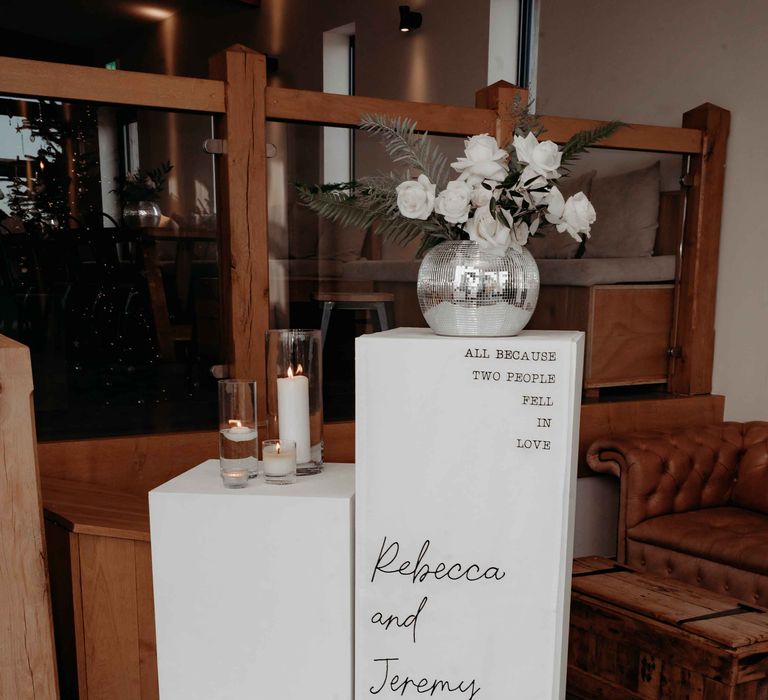 Pillar wedding signage with disco ball decor and candles