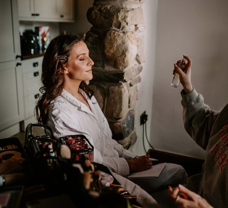 Bride in white satin bridal pyjamas doing bridal preparations photoshoot at Willow Marsh Farm Loughborough 