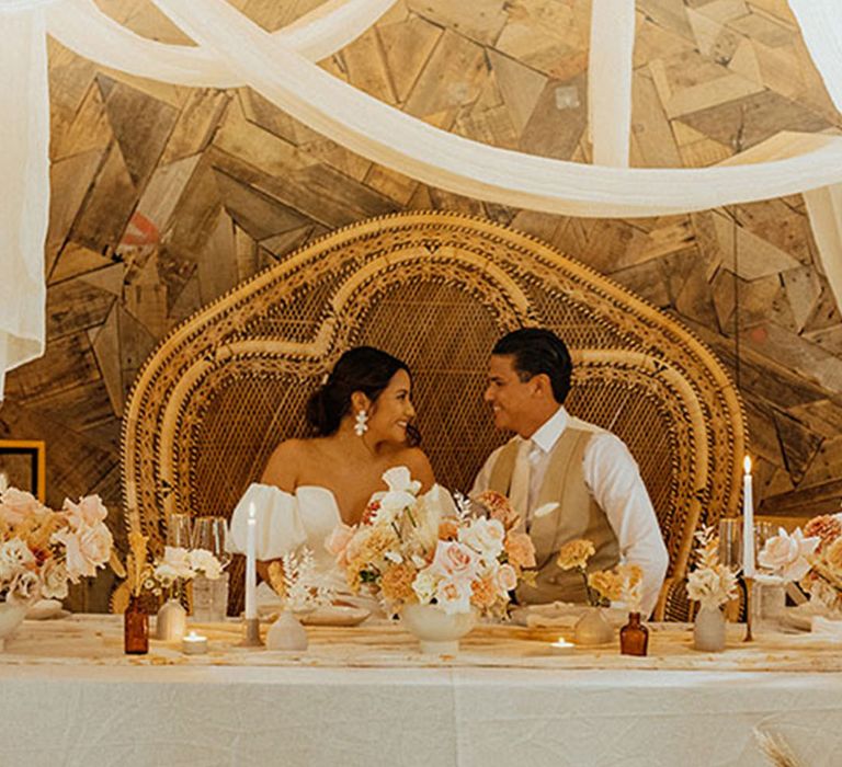 Sweetheart peacock wedding chair for bride and groom sitting at a table just for them as a top table alternative 