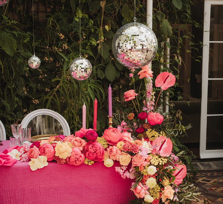 Hot pink wedding sweetheart table decorations with disco ball hanging decor and waterfall flower arrangement 