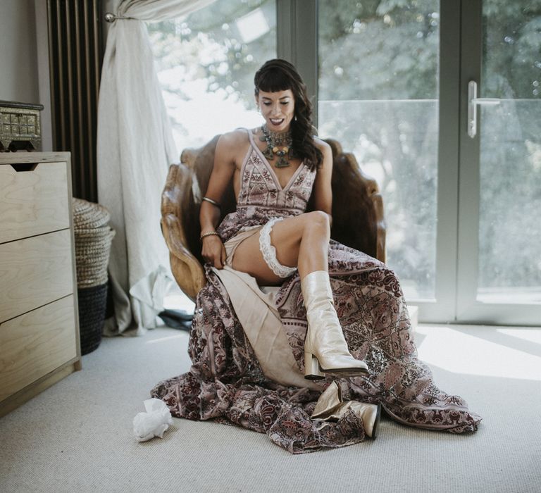 Bride in boho pink wedding dress with aztec wedding jewellery, silver wedding boots and a white frilled garter