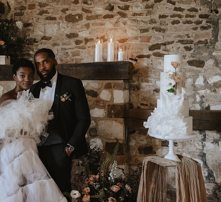 Bride in Millia London wedding dress with groom at soft neutral styled wedding breakfast