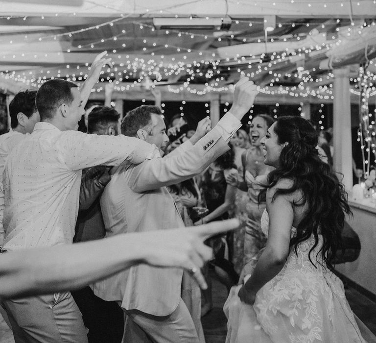 Bride, groom and guests dancing at wedding reception with fairy lights at Restaurant park Hvar wedding