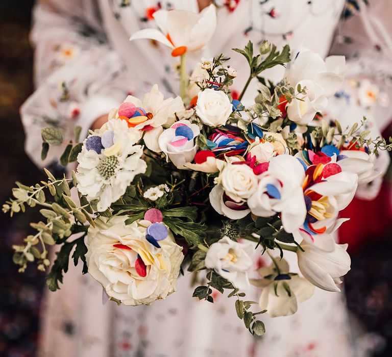 Bride holding all white floral wedding bouquet for contemporary wedding with traditional elements 