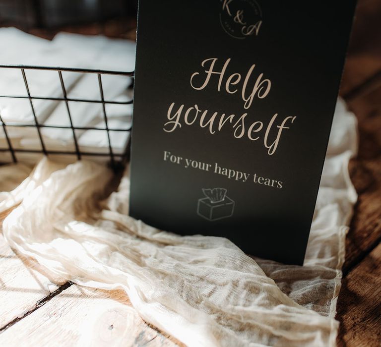 Dark green wedding sign asking guests to help themselves to tissues for the wedding ceremony 