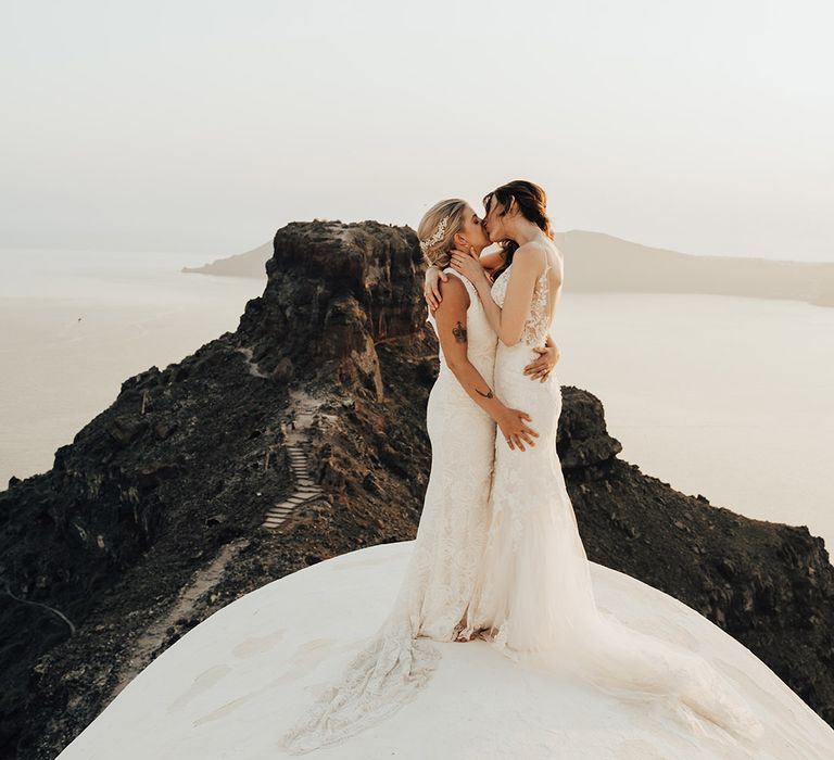 Brides kissing on top of the church at Santorini same sex wedding in Greece 