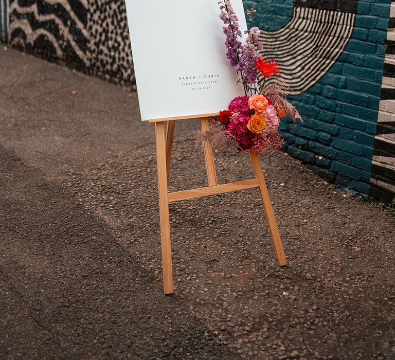 Simple wedding welcome signage with bright flowers