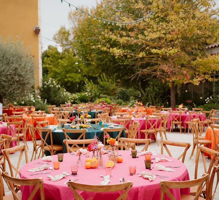 Wedding tables decorated with pink tablecloth and fruit table centrepieces 